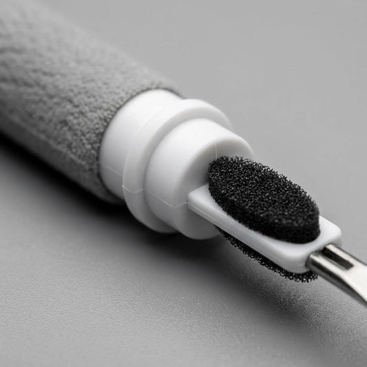 Close-up of the KeyBudz AirCare Lite cleaning tool showing the black sponge brush and tip.