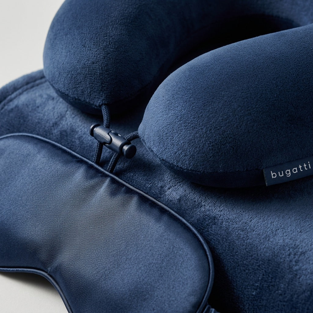 Macro detail of the navy Bugatti travel set showing the plush memory foam pillow and eye shade.