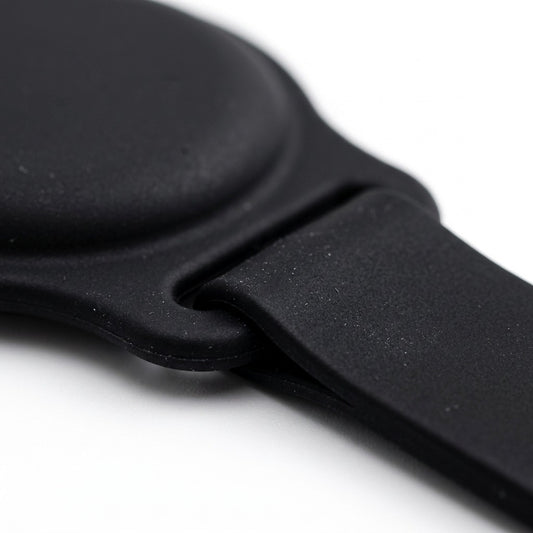 Macro close-up of the black silicone KeyBudz PawTag pet collar mount for Apple AirTag.